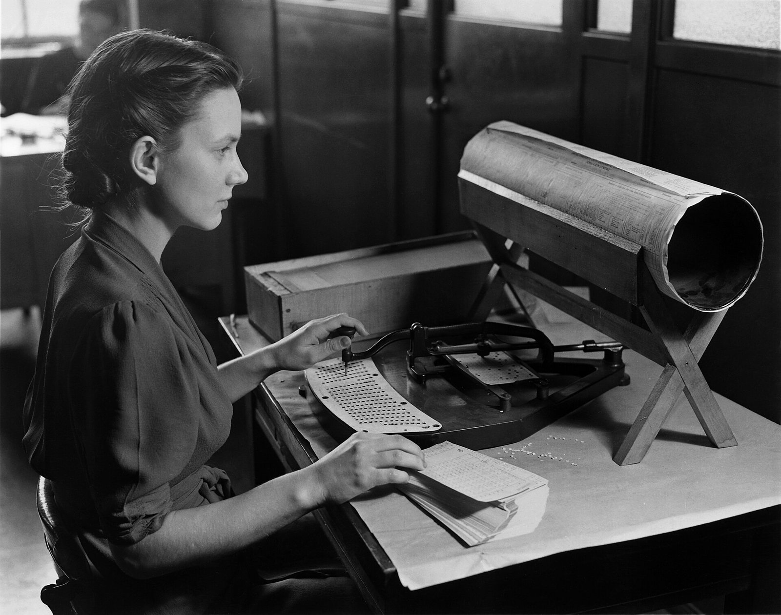 A woman operating a Hollerith pantograph punch, punching the 1940 US census population card